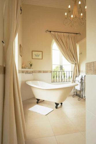 a white bath tub in a bathroom with a window at Villa Howden in Margate