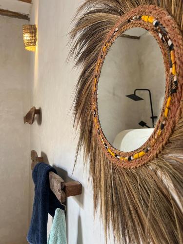a wreath with a mirror on a wall at Bahari Studio by Bora Pamoja Homes Pool, Solar Backup & 5 Min to Beach in Jambiani