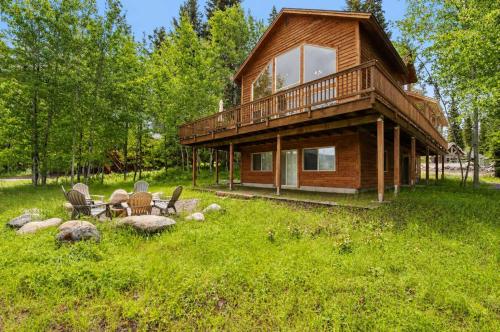 a log cabin with a table and chairs in the grass at Spacious McCall Home Near Golf Course in McCall
