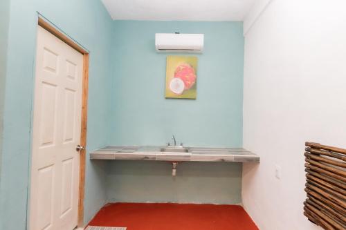 a bathroom with a sink and a painting on the wall at Casa Shalom Green in Bacalar