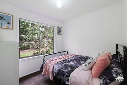 a bedroom with a bed and a large window at Between Waters Stay 3 Pay 2 Winter Special in Yanakie