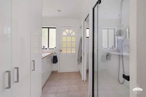 a bathroom with white walls and a glass door at Between Waters Stay 3 Pay 2 Winter Special in Yanakie
