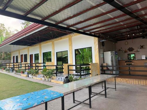 a building with a long table in front of it at CocoVille Guesthouse KUBO in Alegria