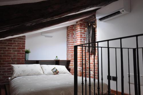 a bedroom with a bed and a brick wall at Alle Volte Torino in Turin