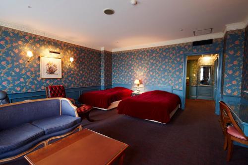 a hotel room with two beds and a couch at Wellness Forest Nasu in Nasu