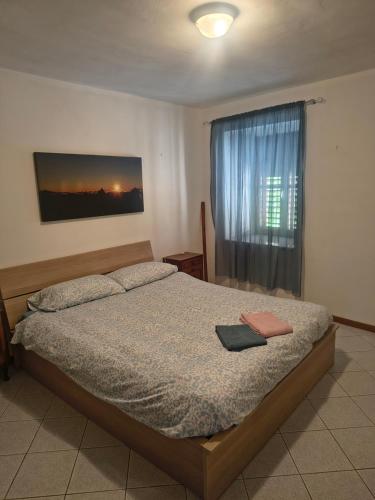 a bedroom with a bed and a window at Casa Viarago in Pergine Valsugana