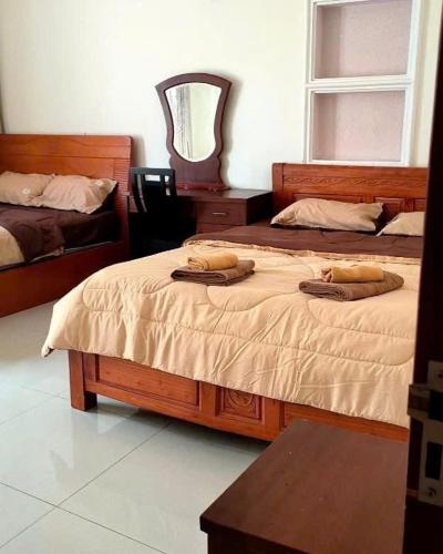 a bedroom with two beds and a chair and a mirror at Homestay Solar Halo in Xã Thang Tam