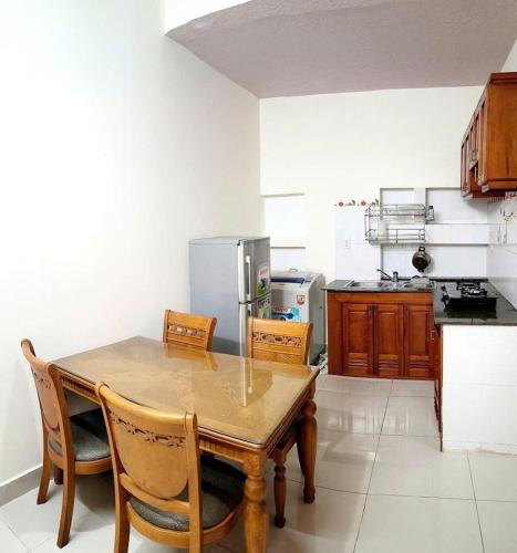 a kitchen with a wooden table and some chairs at Homestay Solar Halo in Xã Thang Tam