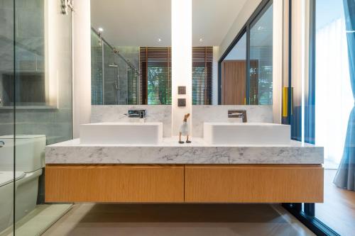 a bathroom with two sinks and a large mirror at Botanica Foresta 4BDR by Villacarte in Ban Phru Champa