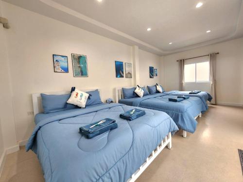 three beds in a room with blue sheets at Serene Poolvilla hatyai in Hat Yai