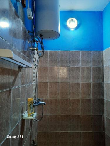 a bathroom with a shower with a blue ceiling at Villa Frisi in Palimé