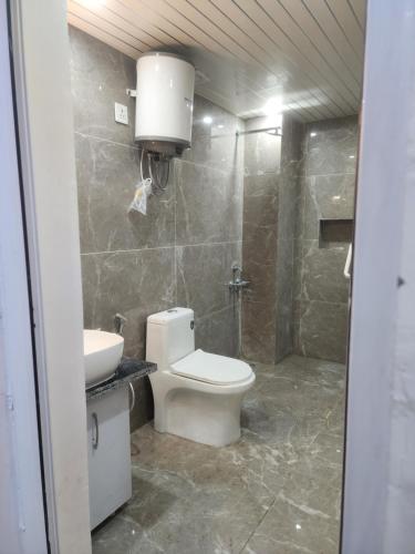 a bathroom with a toilet and a sink at Hazy hill in Mussoorie