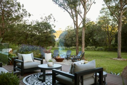 a patio with chairs and tables and a pond at The Pavilion Wamberal in Wamberal