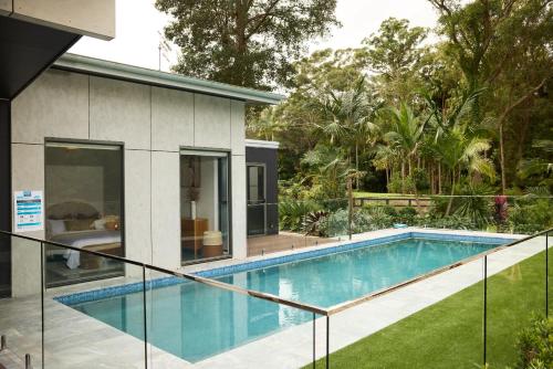a swimming pool in front of a house at The Pavilion Wamberal in Wamberal