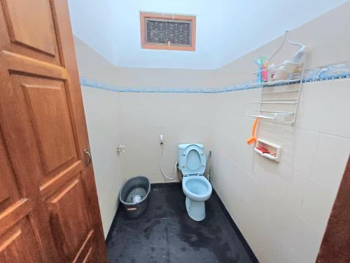 a bathroom with a blue toilet in a room at Ghanaya Guesthouse in Ngaglik
