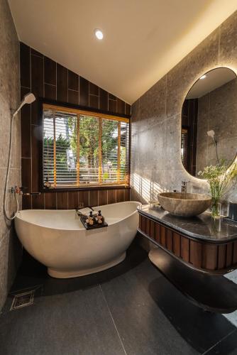 a large bathroom with a tub and a sink at Zen Valley Dalat in Da Lat