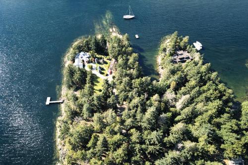 an island in the water with trees and a boat at Valhalla The Loft (Oceanfront Hot tub) in Salt Spring Island