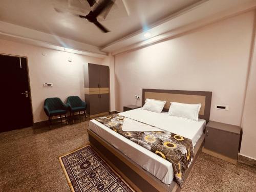 a bedroom with a bed and two chairs in it at Regal Palace Hotel and Banquets in Patna