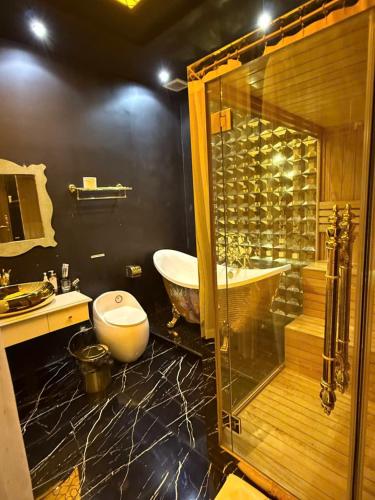 a bathroom with a tub and a glass shower at Athena Hotel Huế in Hue