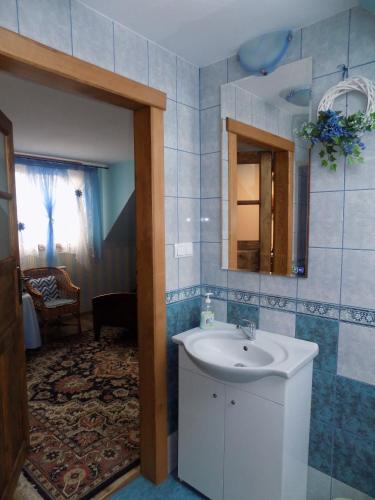 a bathroom with a sink and a mirror at Kwiatowa Zagroda in Białowieża