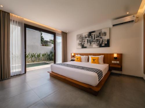 a bedroom with a large bed and a large window at Prawara Uluwatu in Uluwatu