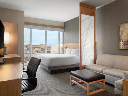 a hotel room with a bed and a couch at Hyatt Place Milwaukee Downtown in Milwaukee