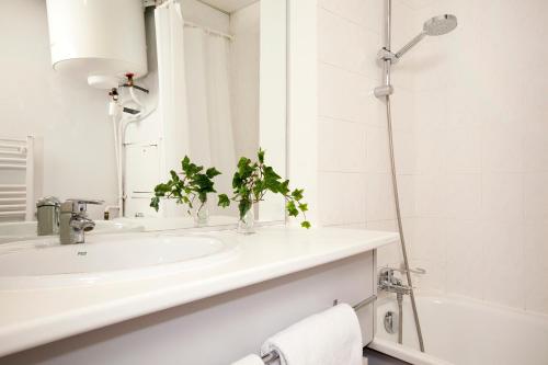 y baño blanco con lavabo y ducha. en Séjours & Affaires Lyon Saxe-Gambetta, en Lyon