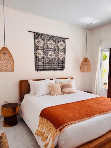 a bedroom with a large white bed with a brown blanket at Gypsea Rest Private Villa in Nusa Lembongan