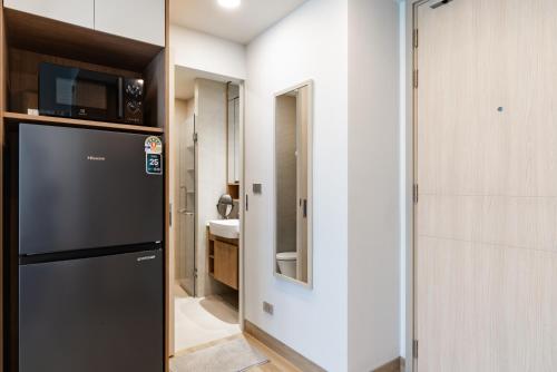 a kitchen with a black refrigerator and a sink at Skypark by Villacarte in Laguna Phuket