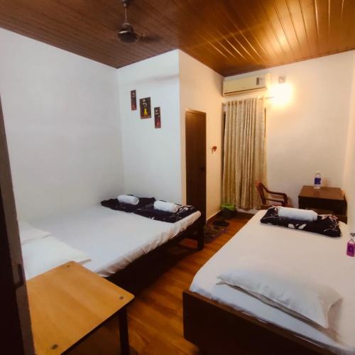 a room with two beds and a table in it at Ebenezer Stay in Trivandrum