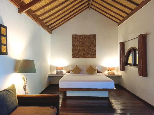 a bedroom with a bed and two lamps and a couch at Laguna Gili in Gili Trawangan