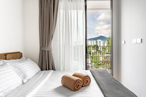 a bedroom with a bed with two towels on it at Skypark by Villacarte in Laguna Phuket