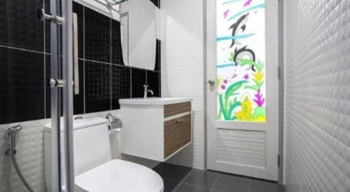 a bathroom with a white toilet and a sink at K Station Pattaya in Pattaya