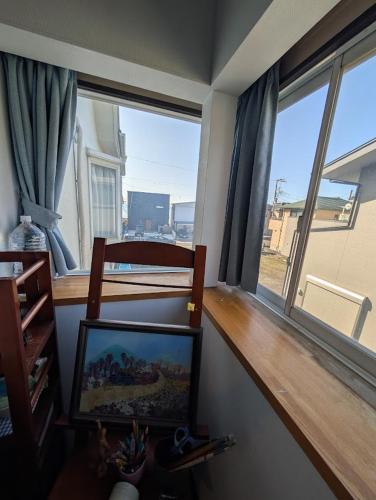 a living room with a flat screen tv and windows at アトイエ-Atoie- in Odawara