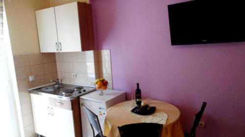 a kitchen with a table with a bottle of wine on it at SARITA Apartments in Makarska