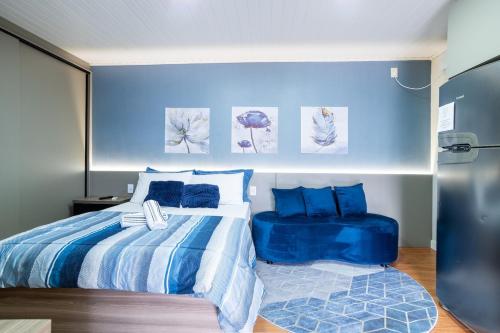 a bedroom with a bed and a blue wall at Studio c Piscina, AC e Café Novo Hamburgo in Novo Hamburgo