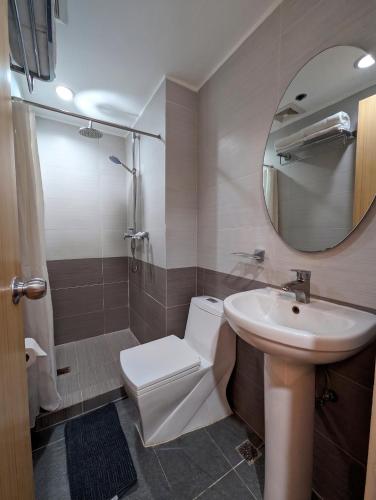 a bathroom with a sink and a toilet and a mirror at Prince Plaza II Condotel in Manila