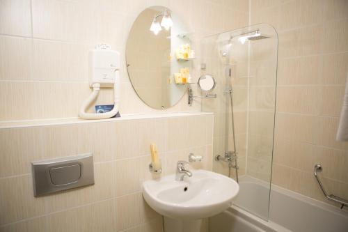 a bathroom with a sink and a shower with a mirror at Kazakhstan Express in Almaty