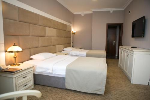 a hotel room with two beds and a television at Kazakhstan Express in Almaty