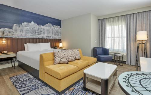 a hotel room with a bed and a couch at Hyatt Centric the Pike Long Beach in Long Beach