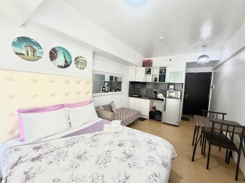 a bedroom with a bed and a table and a kitchen at Centrio Tower Condo Units in Cagayan de Oro