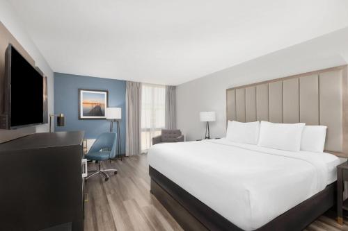 a hotel room with a large bed and a desk at La Quinta by Wyndham Dallas I-35 Walnut Hill Ln in Oldham