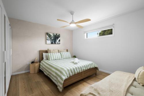 a bedroom with a bed and a ceiling fan at Mellow mountains, boutique beach house in Portarlington
