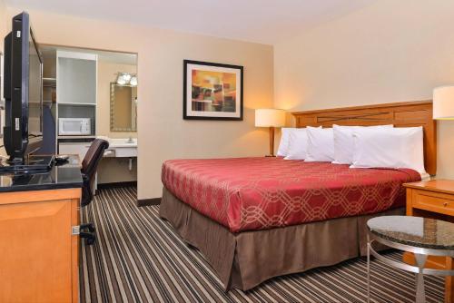 a hotel room with a bed and a television at Econo Lodge Kennewick Tri-Cities in Kennewick