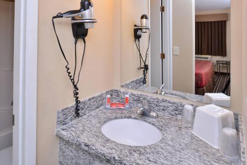a bathroom with a sink with a large mirror at Econo Lodge Kennewick Tri-Cities in Kennewick
