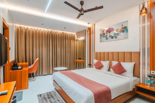 a hotel room with a bed and a desk at Travinities Hotel Shree Ji Palace in Ujjain