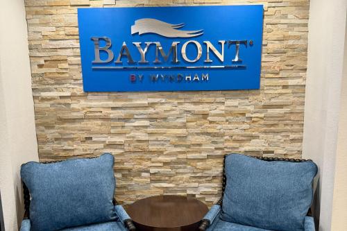 a sign on a wall with two chairs and a table at Baymont by Wyndham Findlay in Findlay