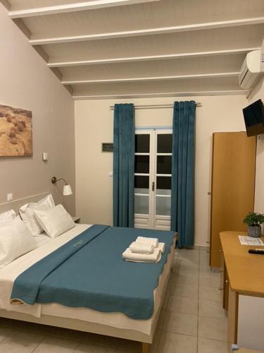 a bedroom with a blue bed and blue curtains at Gregory's Village in Platy