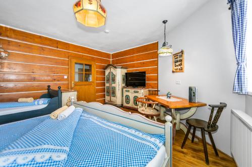 a bedroom with two beds and a table at Penzion Sněžná Volary in Volary