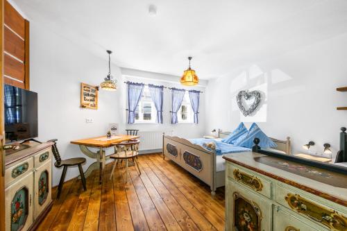 a bedroom with a bed and a table and a desk at Penzion Sněžná Volary in Volary